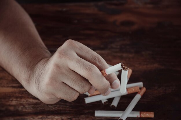 Foto primer plano de la mano sosteniendo un cigarrillo