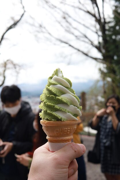 Foto primer plano de una mano sosteniendo un cono de helado