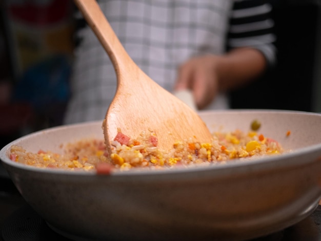Primer plano de la mano sosteniendo fideos en un cuenco