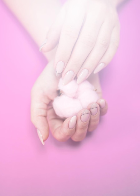 Primer plano de la mano sosteniendo una flor rosada