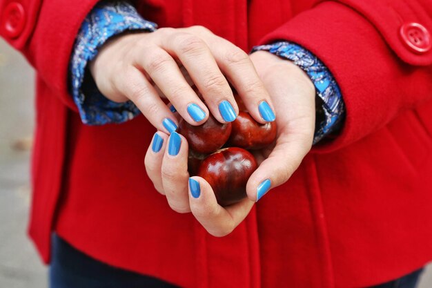 Foto primer plano de una mano sosteniendo una fruta roja