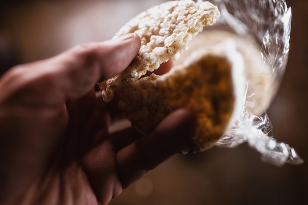 Foto primer plano de una mano sosteniendo un gofre de arroz