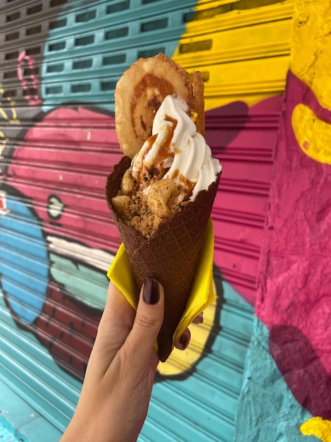 Primer plano de la mano sosteniendo un helado de tocino