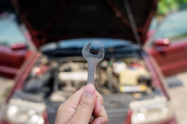 Primer plano de la mano sosteniendo la llave contra el coche