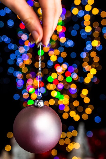 Foto primer plano de una mano sosteniendo luces de navidad iluminadas