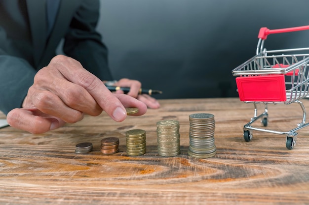 Primer plano de una mano sosteniendo monedas en la mesa