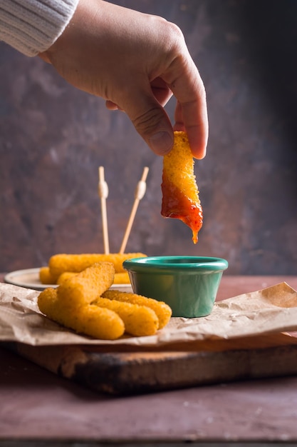 Foto primer plano de una mano sosteniendo una naranja en la mesa