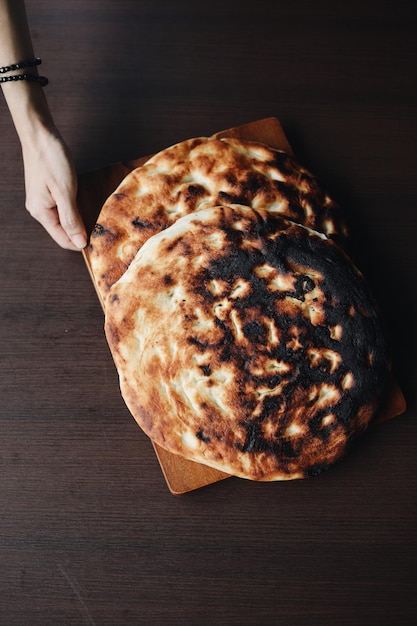 Foto primer plano de una mano sosteniendo el pan en la mesa