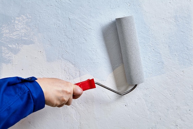 Primer plano de la mano sosteniendo un paraguas contra la pared blanca