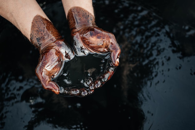 Primer plano de la mano sosteniendo el petróleo crudo