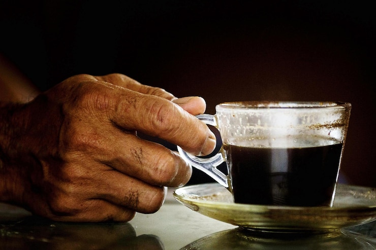 Foto primer plano de una mano sosteniendo una taza de café