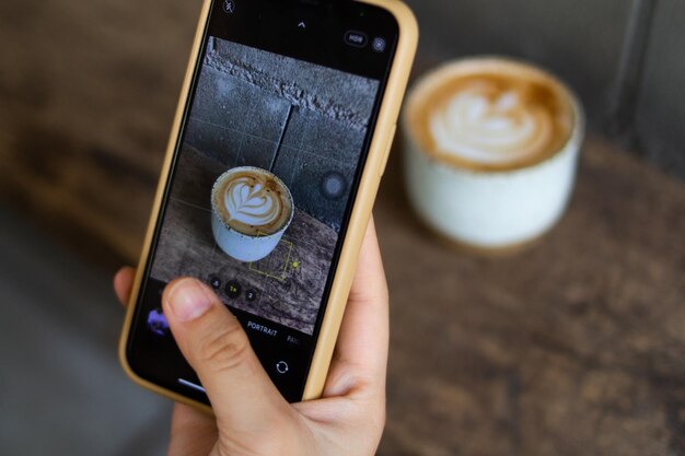 Foto primer plano de una mano sosteniendo una taza de café