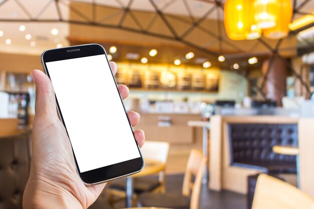 Foto primer plano de la mano sosteniendo un teléfono inteligente en un restaurante