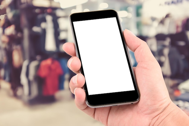 Primer plano de la mano sosteniendo el teléfono inteligente en la tienda