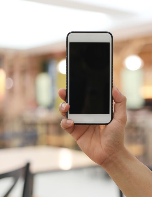 Foto primer plano de la mano sosteniendo el teléfono inteligente