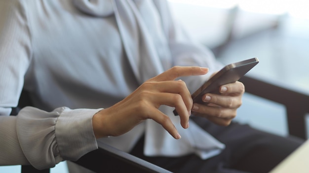 Primer plano de la mano sosteniendo el teléfono móvil