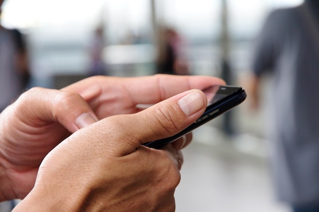 Primer plano de la mano sosteniendo el teléfono móvil