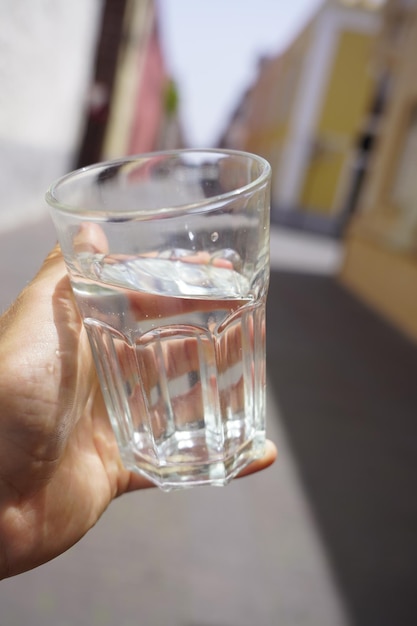 Primer plano de la mano sosteniendo un vaso de agua