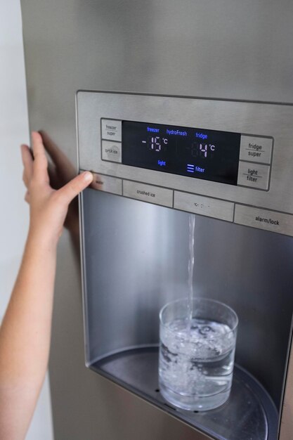 Foto primer plano de la mano sosteniendo un vaso de agua