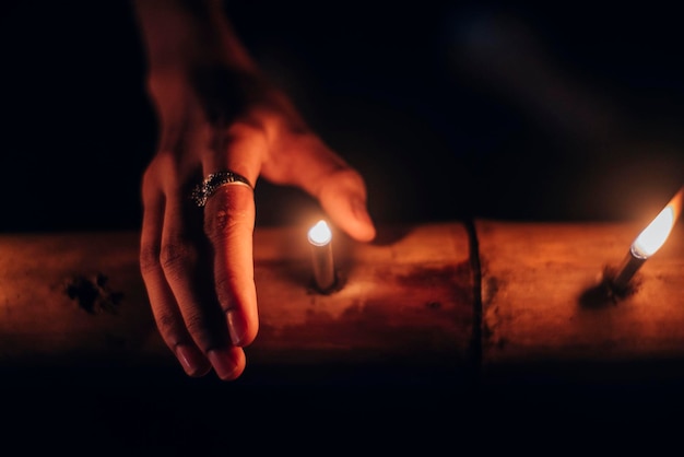 Primer plano de una mano sosteniendo una vela ardiente