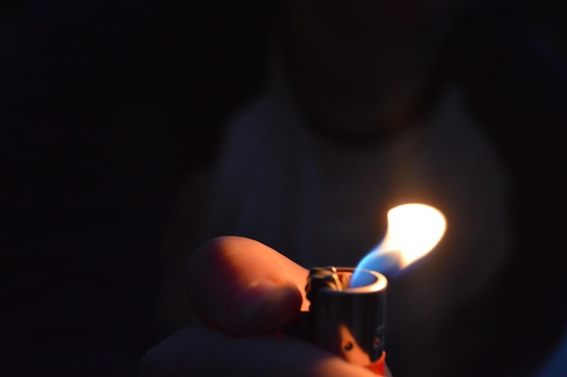 Foto primer plano de una mano sosteniendo una vela iluminada