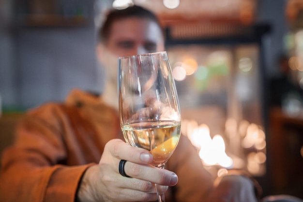 Primer plano de la mano sosteniendo vino blanco acogedora chimenea engelberg resort