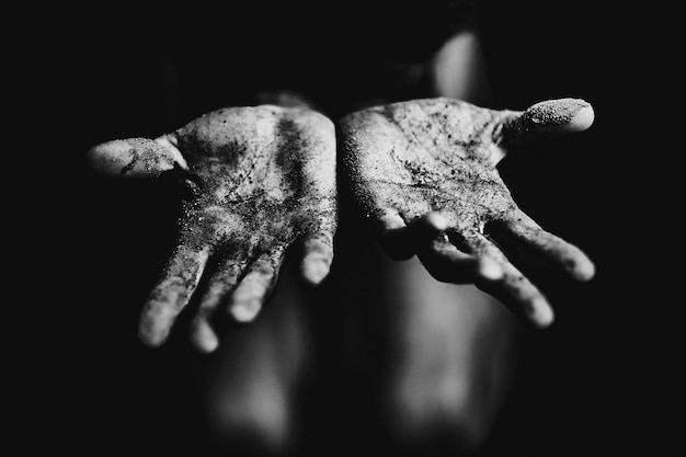 Foto primer plano de la mano sucia contra un fondo negro