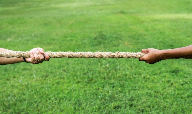 Foto primer plano de mano tirando de la cuerda en juego de tira y afloja