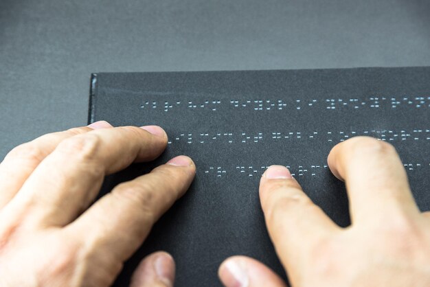 Foto primer plano de la mano tocando el braille