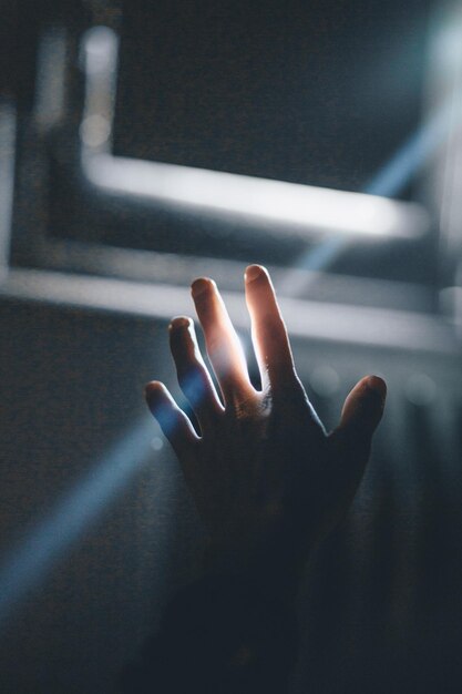 Primer plano de la mano tocando la luz iluminada