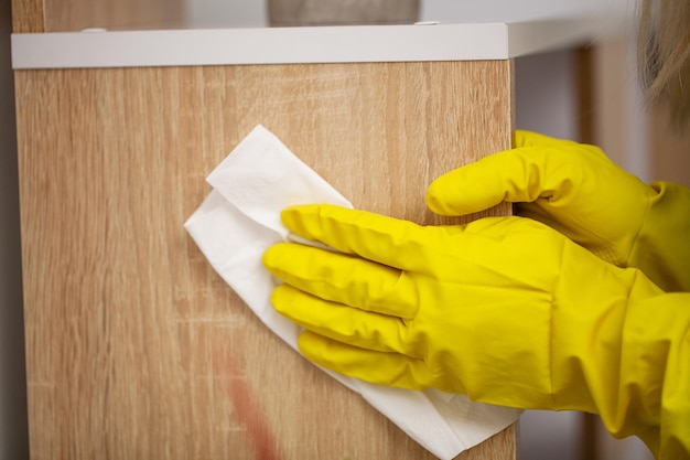 Primer plano de la mano del trabajador limpiando el polvo en la oficina.