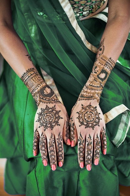 Primer plano de la mano trasera de la novia india con mehndi (tatuaje de henna) con una hermosa sari
