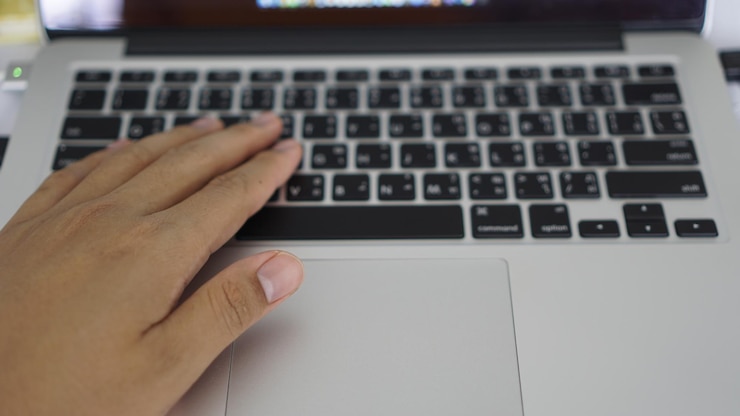 Foto primer plano de la mano usando una computadora portátil