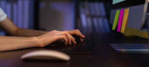 Primer plano de la mano usando la computadora y el teclado escribiendo en Internet en línea.