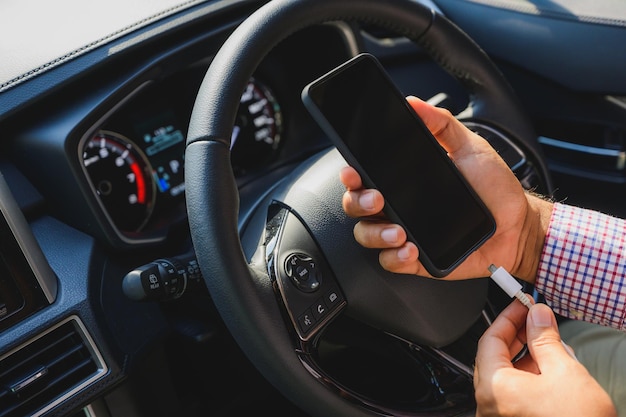Primer plano de la mano usando el teléfono inteligente en el coche