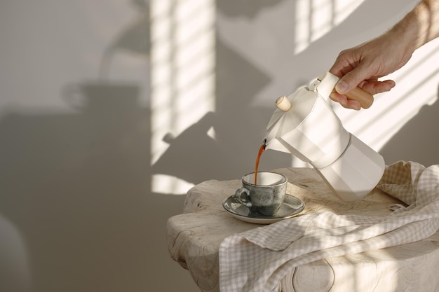 Primer plano de la mano vertiendo la taza de té