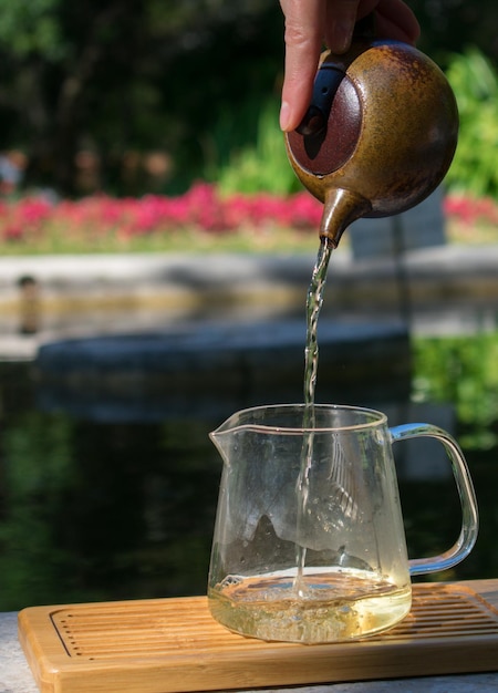 Foto primer plano de la mano vertiendo té en el vaso