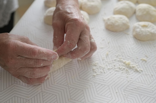Primer plano de las manos de la abuela Anciana cocina pasteles en la cocina