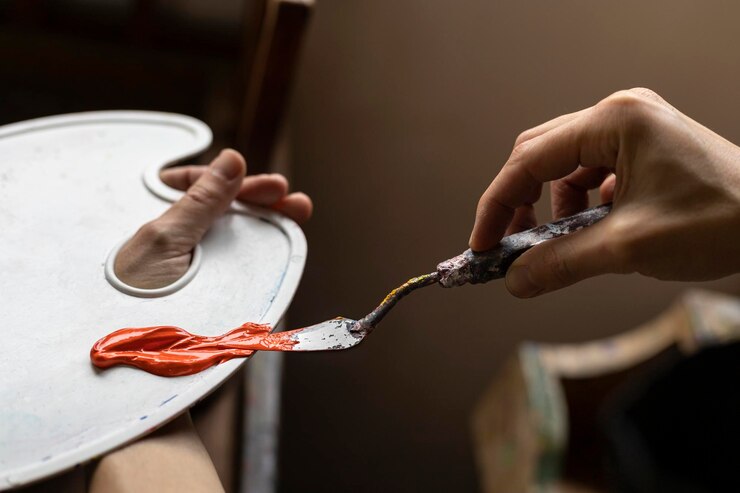 Primer plano de las manos de un artista latinoamericano irreconocible que muestra la paleta y el cuchillo de paleta con las pinturas que usa para pintar en su estudio de arte Concepto de artista y afición