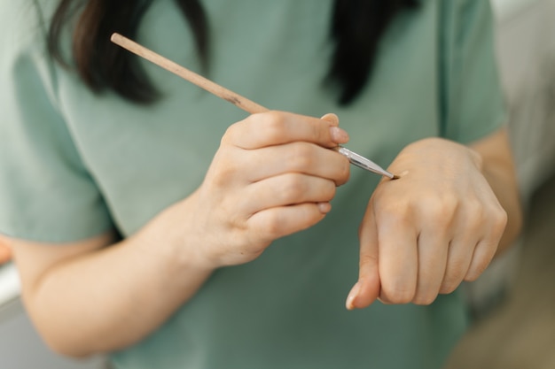 Primer plano de las manos de la artista de maquillaje de mujer irreconocible pruebas cepillo