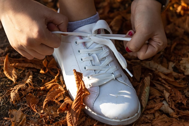 Primer plano de las manos del atleta atándose los cordones de los zapatos Manos del atleta atándose los cordones de los zapatos