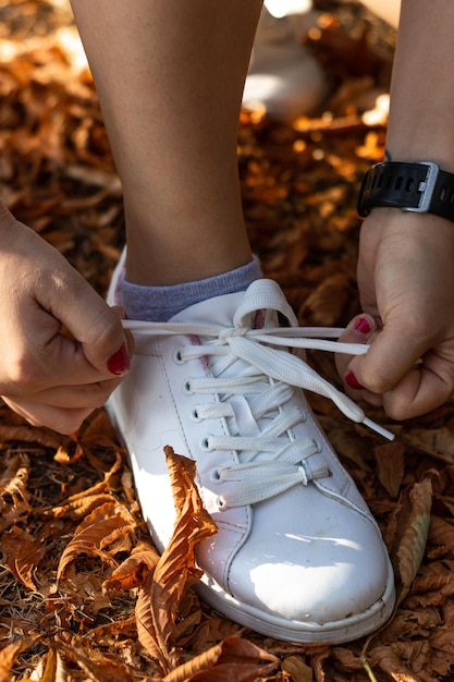 Primer plano de las manos del atleta atándose los cordones de los zapatos Manos del atleta atándose los cordones de los zapatos