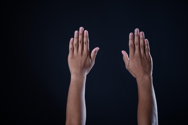 Primer plano de las manos contra un fondo negro