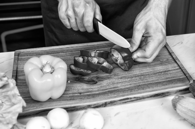 Primer plano de manos cortando verduras con un cuchillo