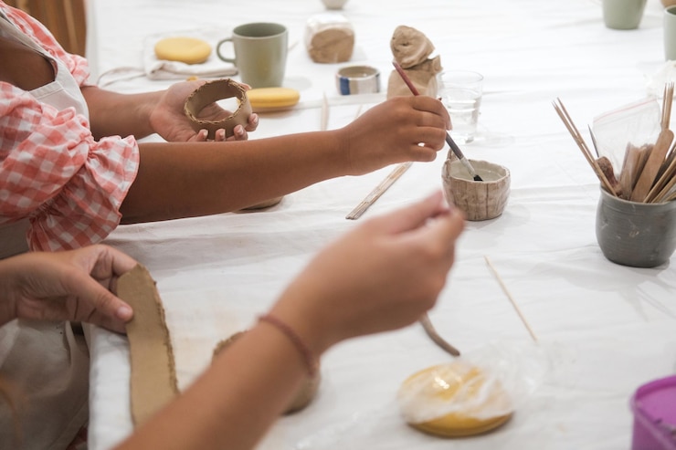 Foto un primer plano de las manos de dos mujeres diversas que están sentadas en un taller de arte