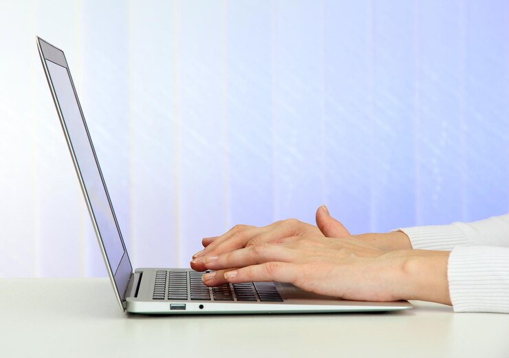 Foto primer plano de las manos de la empresaria escribiendo en la computadora portátil