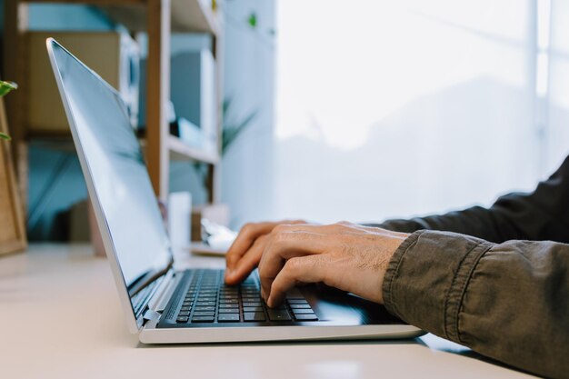 Primer plano de las manos escribiendo en una computadora portátil