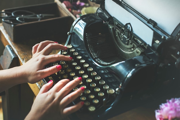 Foto primer plano de las manos escribiendo máquina de escribir retro clásica