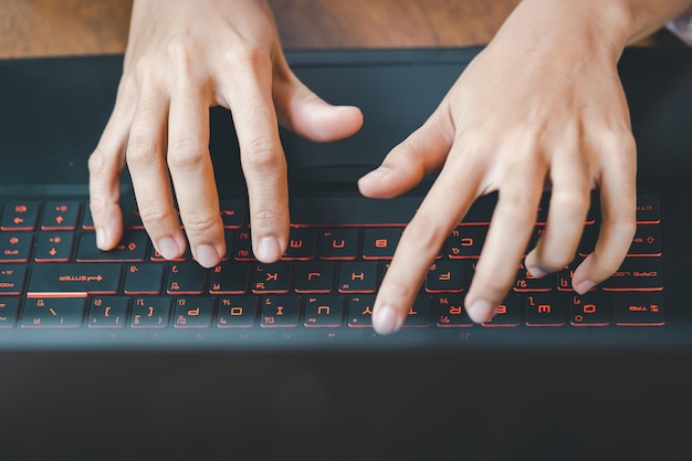 Primer plano de manos femeninas escribiendo en la computadora portátil en la oficina