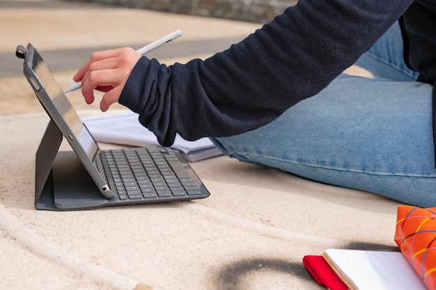 Primer plano de manos femeninas escribiendo en el teclado de una computadora portátil Mujer joven que estudia y trabaja en el parque